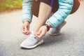 Girl runner tying laces for jogging her shoes on road in a park. Running shoes, Shoelaces. Exercise concept. Sport Royalty Free Stock Photo