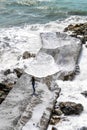 Girl running away from waves splashing all around her Royalty Free Stock Photo