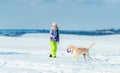 Girl running with dog in snow Royalty Free Stock Photo