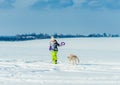 Girl running with dog in snow Royalty Free Stock Photo