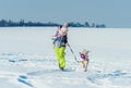 Girl running with dog in snow Royalty Free Stock Photo