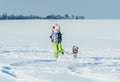 Girl running with dog in snow Royalty Free Stock Photo