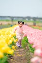 A girl running in the middle of tulip flower garden.