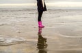 Girl is running with rubber boots at the beach Royalty Free Stock Photo