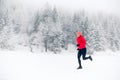 Girl running on snow in winter mountains. Sport, fitness inspiration and motivation. Young happy woman trail running in mountains Royalty Free Stock Photo