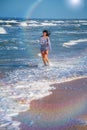 Girl runs along the beach in the waves, happy state of mind Royalty Free Stock Photo