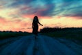 A girl runs along a field road without touching the ground in the evening at sunset a silhouette against the multicolored sky Royalty Free Stock Photo