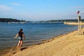 A girl runs along the shore on a sunny simmerÃ¢â¬â¢s day