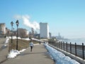 The girl runs along the spring embankment on a spring day