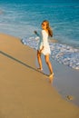 Girl runs along the surf line