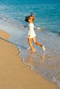 Girl runs along the surf line