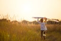 A girl runs into a field with a kite, learns to launch it. Outdoor entertainment in summer, nature and fresh air. Childhood,