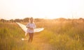 A girl runs into a field with a kite, learns to launch it. Outdoor entertainment in summer, nature and fresh air. Childhood, Royalty Free Stock Photo