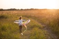 A girl runs into a field with a kite, learns to launch it. Outdoor entertainment in summer, nature and fresh air. Childhood, Royalty Free Stock Photo