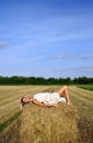 Girl in a rural clothing lying on the haystack