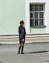 Girl in russian police uniform stands against the wall of the He