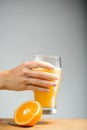 Girl s arm holding glass of orange juice. Royalty Free Stock Photo
