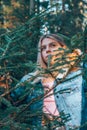 The girl`s gaze through the foliage in the woods.