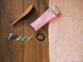 Girl`s hair care items on a wooden table. Bottle of shampoo, brush, metal clips, pink towel, elastic bands Royalty Free Stock Photo