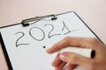 girl's hand close up with a marker written on a sheet of A4 paper with numbers 2021 New Year makes a plan Royalty Free Stock Photo