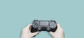 Girl`s hand holding game controller isolated on pastel blue background Royalty Free Stock Photo