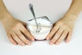 Girl's hand holding plastic jar with an open lid foil