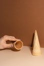 The girl`s hand with ice-cream waffle cones isolated on beige background Royalty Free Stock Photo