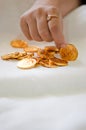 A girl's hand picking up a gold coin from a pile Royalty Free Stock Photo