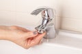 The girl`s hand twists off twists the faucet aerator in the bathroom