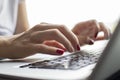 Girl`s hand typing on a laptop keyboard, she presses Enter key, moment of confirmation, close-up Royalty Free Stock Photo