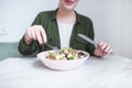 Girl`s hands with cutlery over a plate of salad. A girl eats a salad with a fork and a knife. Healthy Eating