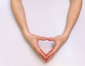 The girl`s hands with extended manicure  on a bright table have folded a heart. Royalty Free Stock Photo