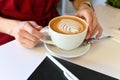 Girl`s hands hold a pint of latte with beautiful foam Royalty Free Stock Photo