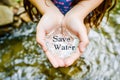 A girl\'s hands hold water with the words save water. Concept of saving water in the face of drought Royalty Free Stock Photo