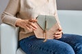 the girl's hands are holding a wicker green-brown handbag