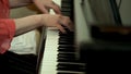 Girl`s hands on the keyboard of the piano. The girl plays piano,close up piano. Hands on the white keys of the Piano Royalty Free Stock Photo