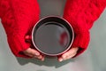 Girl`s hands in red knitted mittens holding cup with coffee Royalty Free Stock Photo