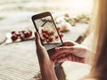 Girl`s hands taking photo of breakfast with strawberries by smartphone. Healthy breakfast Royalty Free Stock Photo