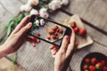 Girl`s hands taking photo of breakfast with strawberries by smartphone. Healthy breakfast Royalty Free Stock Photo