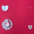 Girl`s hat combined with various hearts on a red background with copy space. Flat lay minimalistic scene