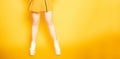Girl`s legs on a bright orange background with very high heels. Go-go or strip dancing. shoe store