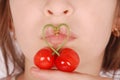 Girl`s lower part of face with two red cherries fruits with heart shaped stem Royalty Free Stock Photo