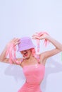 Girl 90s party hip-hop style posing in white studio. Trendy pink jumpsuit, bucket hat and pink hair. Fashion unicorn Lady vibes Royalty Free Stock Photo