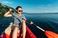 Girl sails on a kayak, paddles with a paddle.