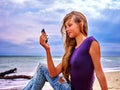 Girl on sand near sea call help by phone. Royalty Free Stock Photo