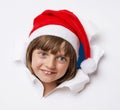 Girl with santa cap looking out of a hole in a paper Royalty Free Stock Photo