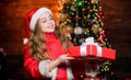 Girl santa claus costume hold christmas gift box. Prepare surprise gift. Open gift. Happy moments. Winter holidays Royalty Free Stock Photo
