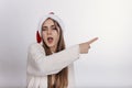 He girl in santa claus hat pointing something by her finger Royalty Free Stock Photo