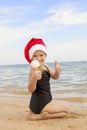 Girl in santa hat on the beach Royalty Free Stock Photo