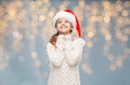 Girl in santa hat dreaming over christmas lights Royalty Free Stock Photo